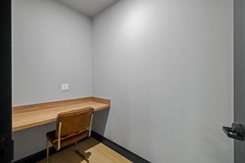 a desk in a corner of a room with a chair